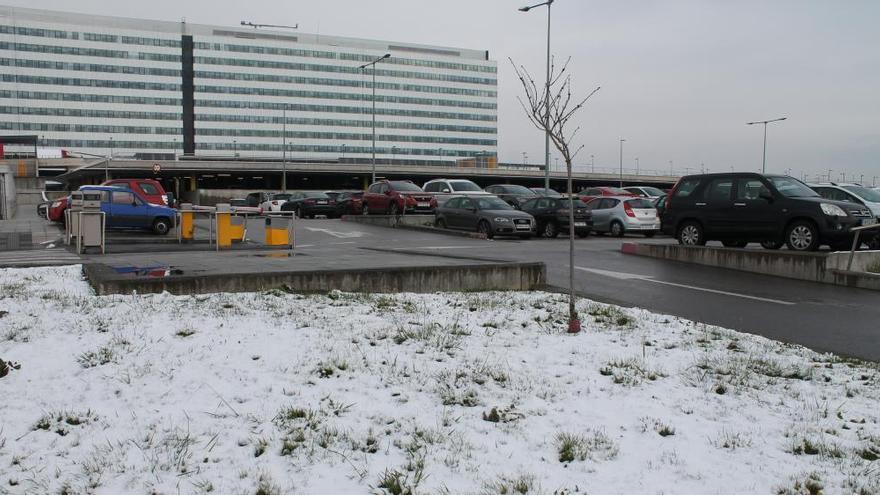 La zona verde, ayer nevada, por la que los ladrones sortearon las barreras del parking.