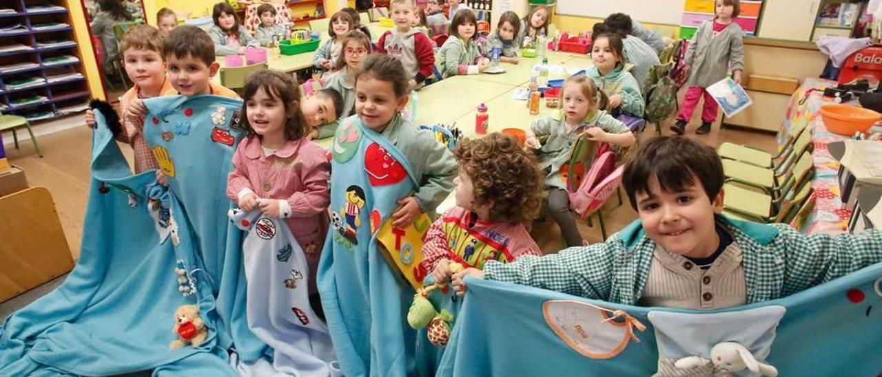 Los alumnos de Educación Infantil muestran las mantas colectivas con los primeros adornos.