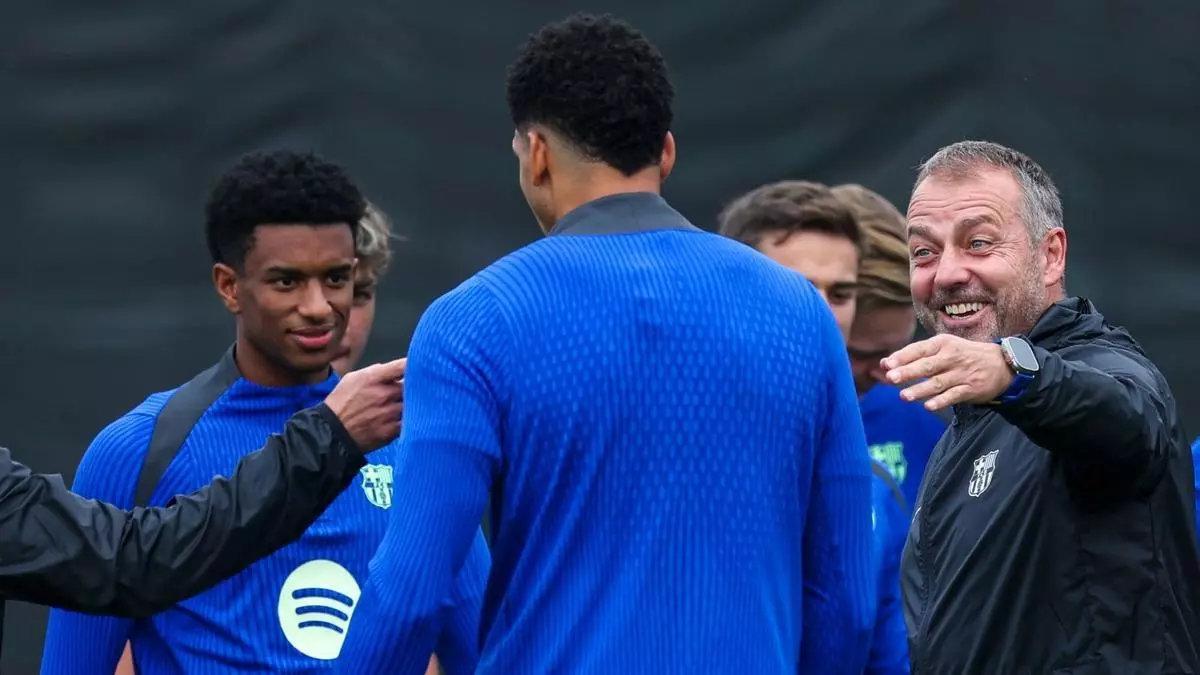 Hansi Flick ríe al dirigirse a Ronald Araujo en el inicio del entrenamiento de este lunes.