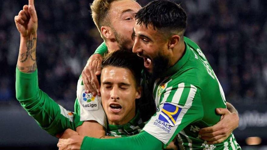 Los verdiblancos Fekir y Loren abrazan a Cristian Tello, autor del gol que dio ayer la victoria al Betis ante el Real Madrid en el Villamarín. // Efe