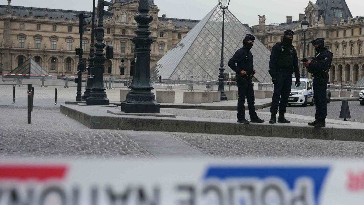 Policías franceses ante el Museuo del Louvre tras el robo.