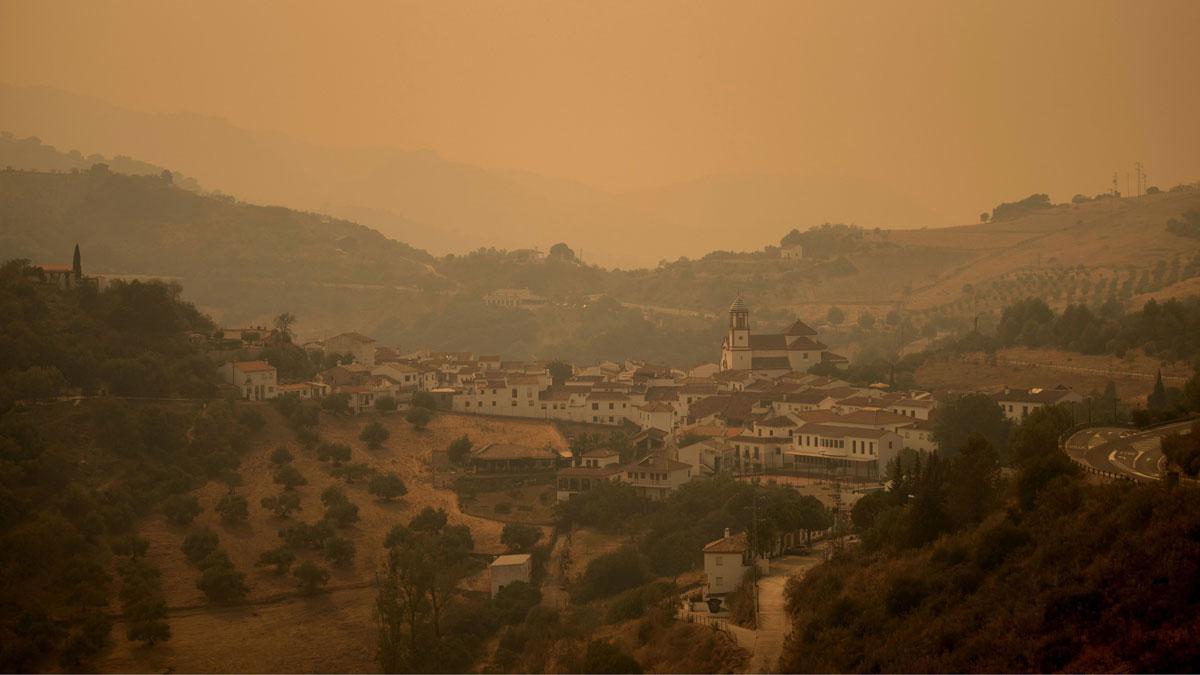 El incendio de Sierra Bermeja (Málaga) ya afecta a 7.400 hectáreas. En la foto, la población de Atajate, envuelta en humo, a causa del fuego.