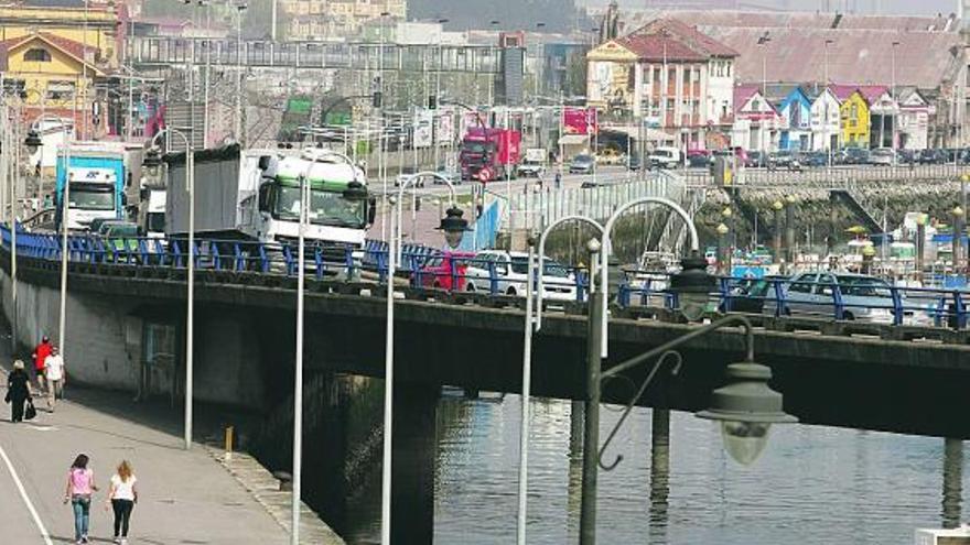 Vehículos circulando por la carretera de la ría a la altura del puerto deportivo de Avilés.