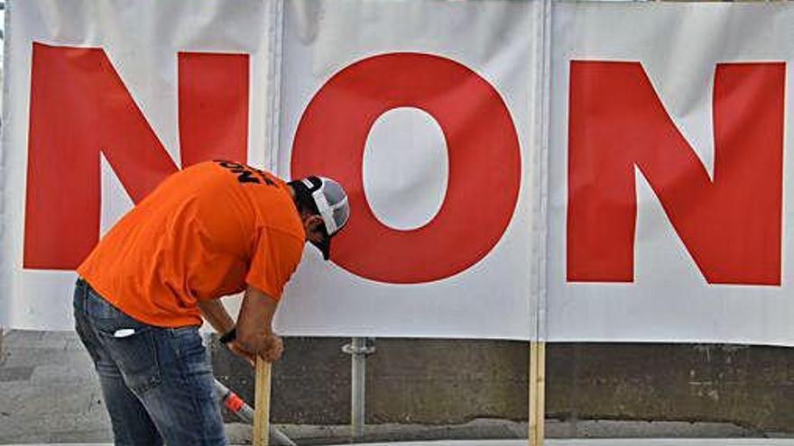 Un trabajador de Alcoa en A Coruña, ante un cartel de &#039;peche non&#039;.