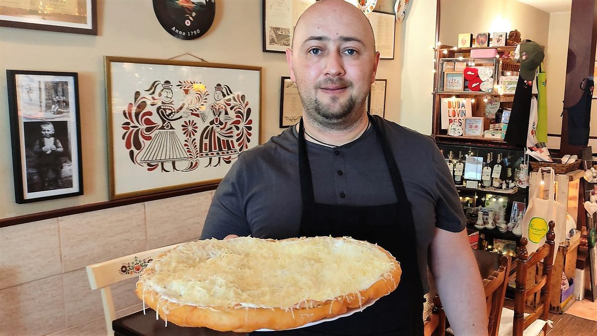 El cocinero Zsolt Beke, del restaurante Hungaryto, con el descomunal 'lángos' recién cocinado.