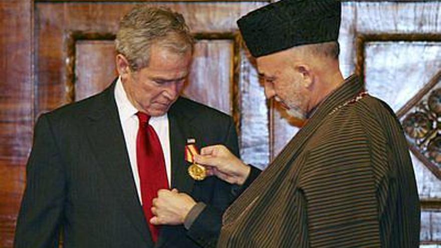 El presidente de Estados Unidos, George W.Bush (i), recibe una medalla de su homólogo afgano, Hamid Karzai, durante el encuentro que mantuvieron en el palacio presidencial de Kabul, Afganistán