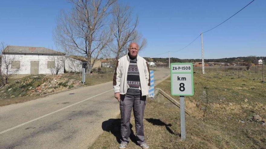 El alcalde de Villanueva de las Peras, Juan García, en la carretera de acceso a la localidad.