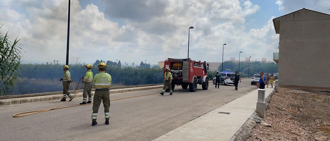 Bomberos y policías en plenas tareas de extinción.