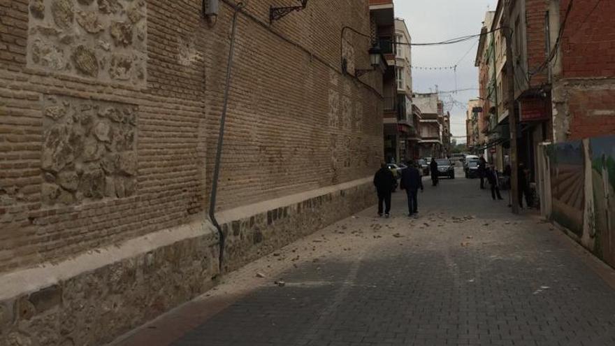 Un tractor roza con la iglesia de Beniel.