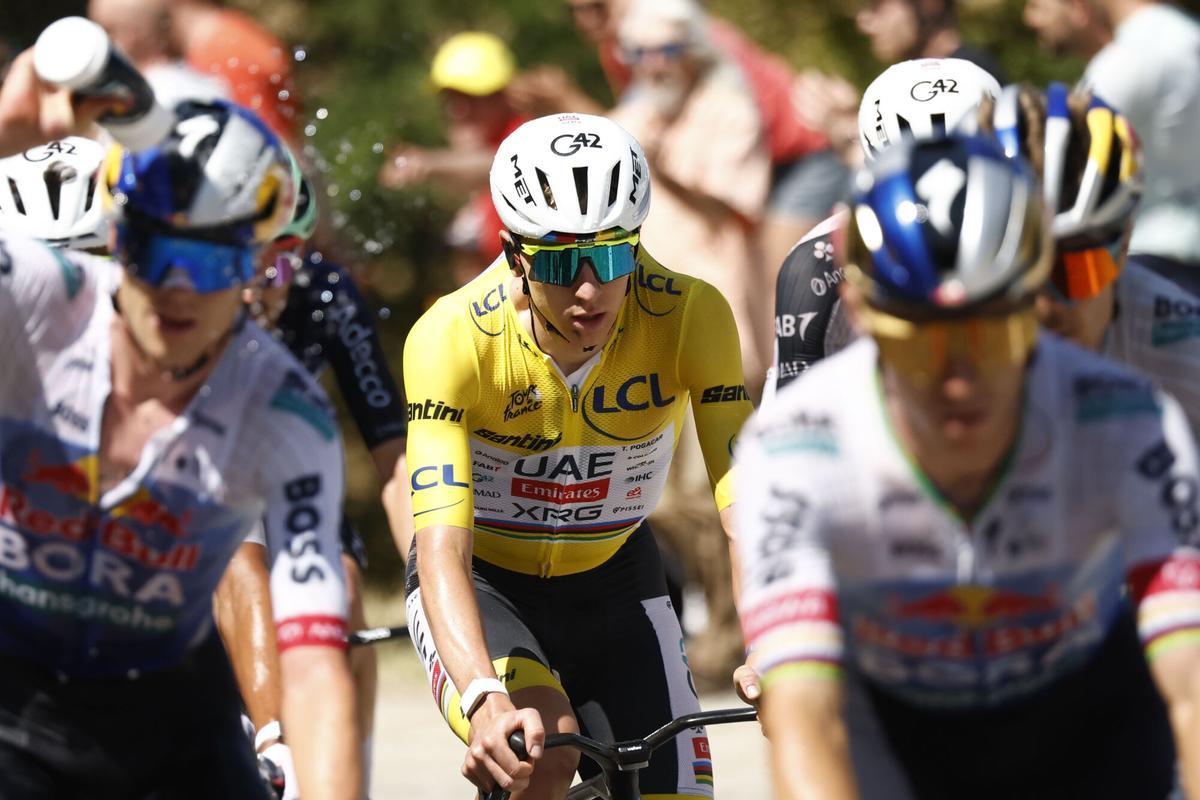 El ciclista Pogacar, maillot amarillo, durante la etapa 18 del Tour de Francia junto a otros ciclistas que se refrescan ante las altas temperaturas.