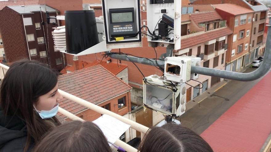 Tres alumnas toman medidas en la estación meteorológica situada en la azotea del colegio.