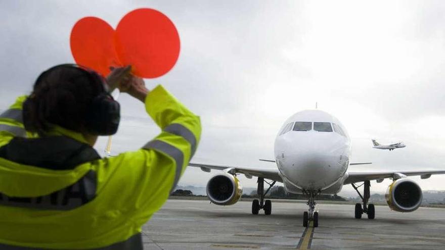 Un operario de Alvedro hace indicaciones a los pilotos de un avión.