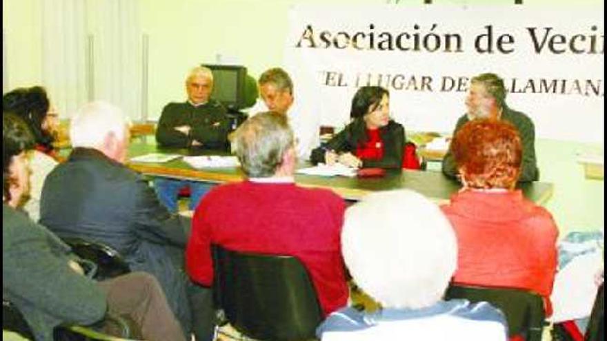 Paloma Sainz, en la mesa, reunida con vecinos y representantes de la asociación «El Llugar de Villamiana». Arriba, la propuesta del PSOE.