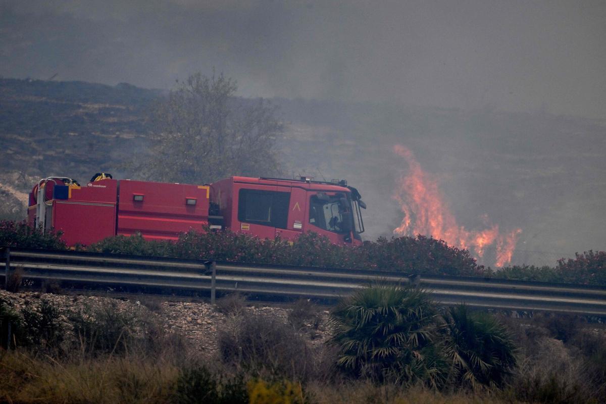 Una foto tomada el 10 de julio de 2026 muestra un camión de bomberos en una carretera junto a las llamas, en el área de un incendio forestal que mató a 11 personas cerca de Bedar, en el distrito de Los Gallardos, en la provincia de Almería.