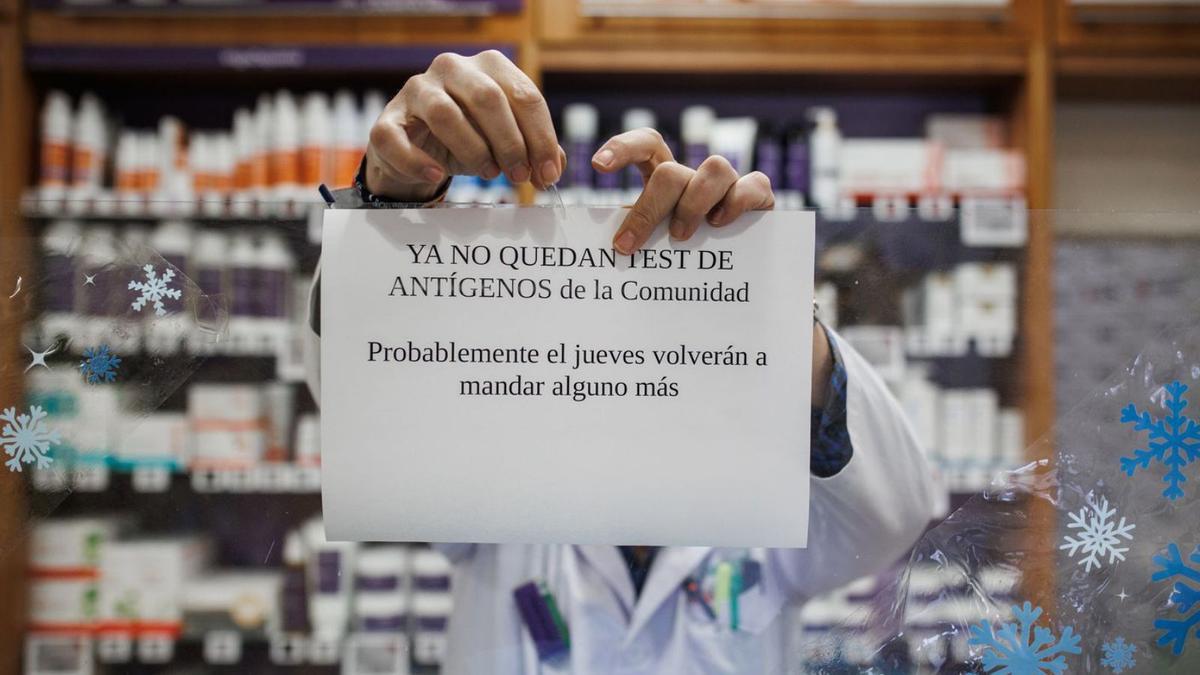 Un farmacéutico cuelga un cartel en su botica avisando de que no quedan test de antígenos. |  // EUROPA PRESS