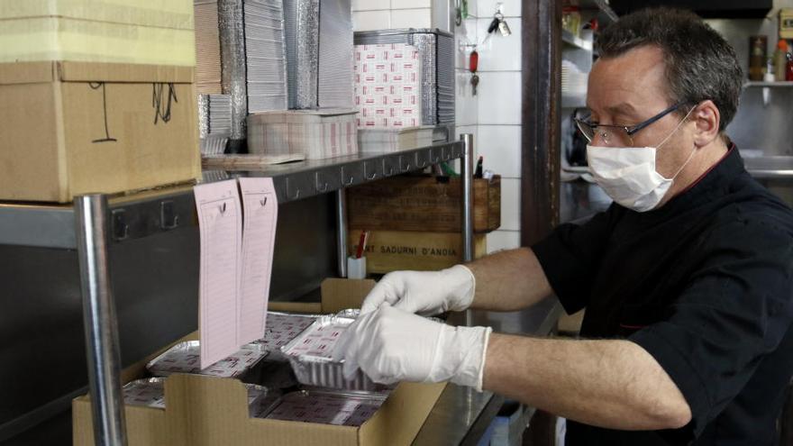 Un dels treballadors del restaurant La Dolceta de Lleida prepara el foc per fer el menjar que serviran a domicili