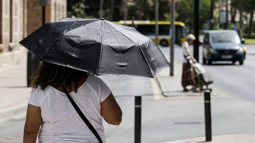 Una mujer se protege del sol este sábado en Murcia.