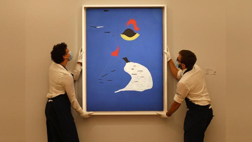 Uns operaris col·loquen la pintura de Miró