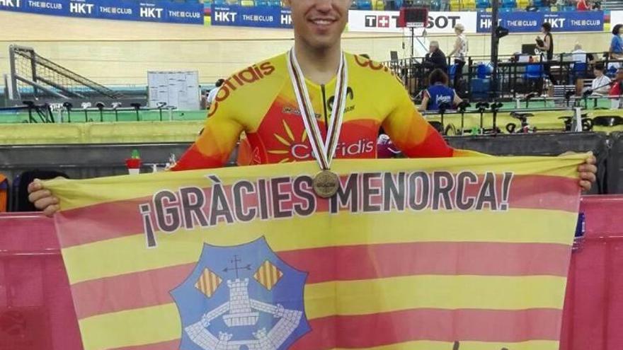 Torres posa con su bronce y la bandera de Menorca.