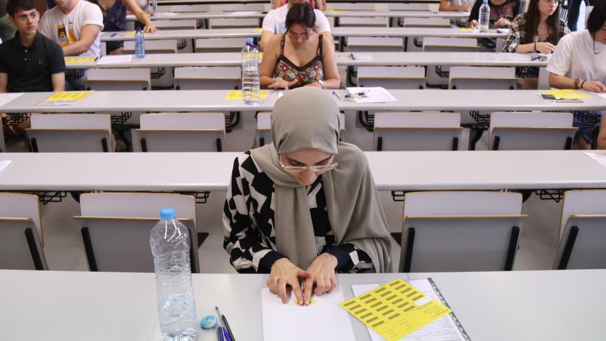 Alumnes enganxen l&#039;etiqueta identificativa abans de començar l&#039;examen de castellà de les PAU, al Campus Catalunya de la URV, a Tarragona