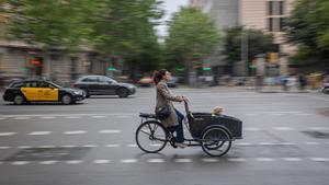 Un madre lleva su hijo en una ’cargo bike’ por la Gran Via, este miércole