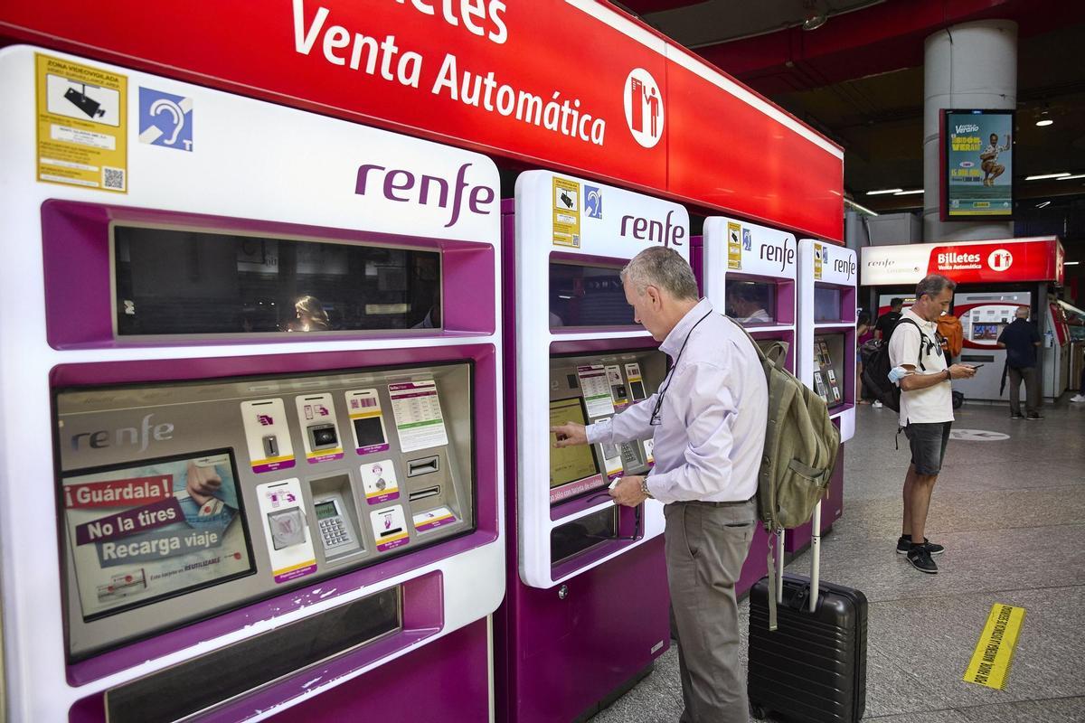 Una persona en una de las máquinas de venta de billetes en la estación Madrid-Atocha Cercanías, a 8 de agosto de 2022, en Madrid (España). Renfe abre hoy el registro en su web para que los clientes puedan solicitar el abono gratuito, que comenzará a funci