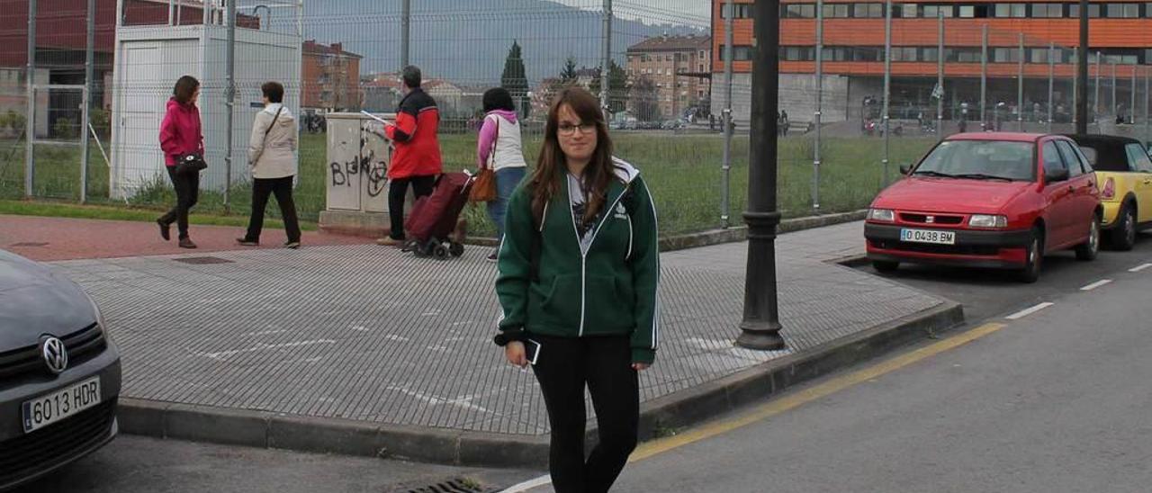 Alba López, ayer, con el medidor de la calidad del aire y varios paseantes, detrás, en la zona del Instituto Astures.