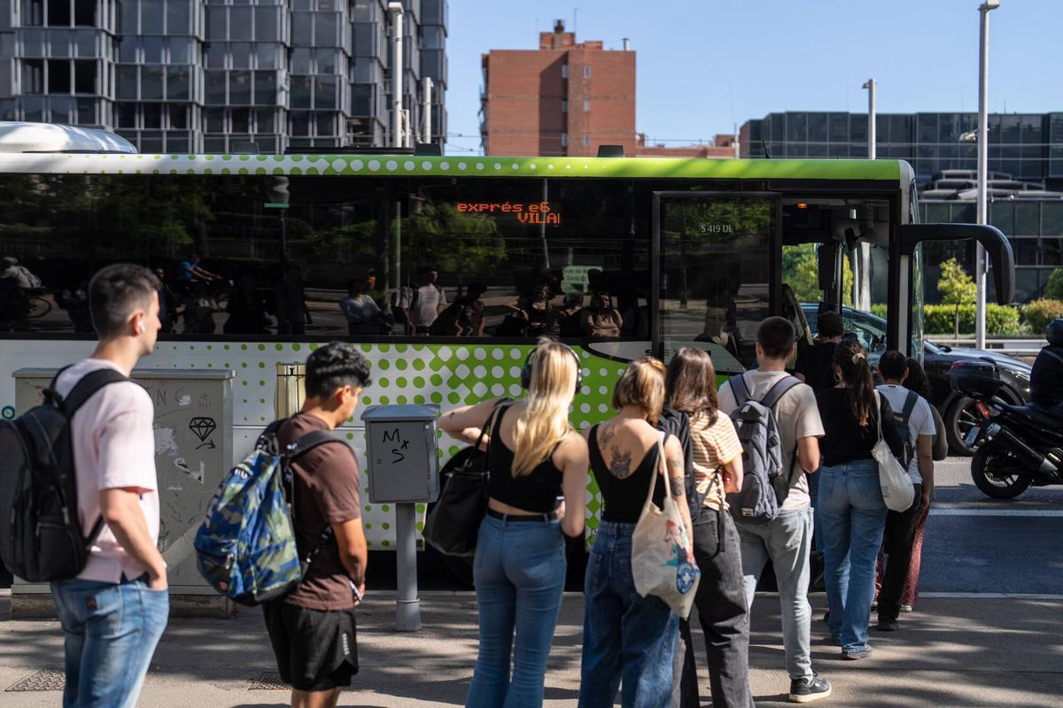 Usuarios, trabajadores y estudiantes hacen cola para subir a los autobuses Exprés.cat en las paradas de Diagonal con Maria Cristina