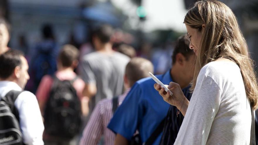 Una mujer, chateando con su &#039;smartphone&#039;.