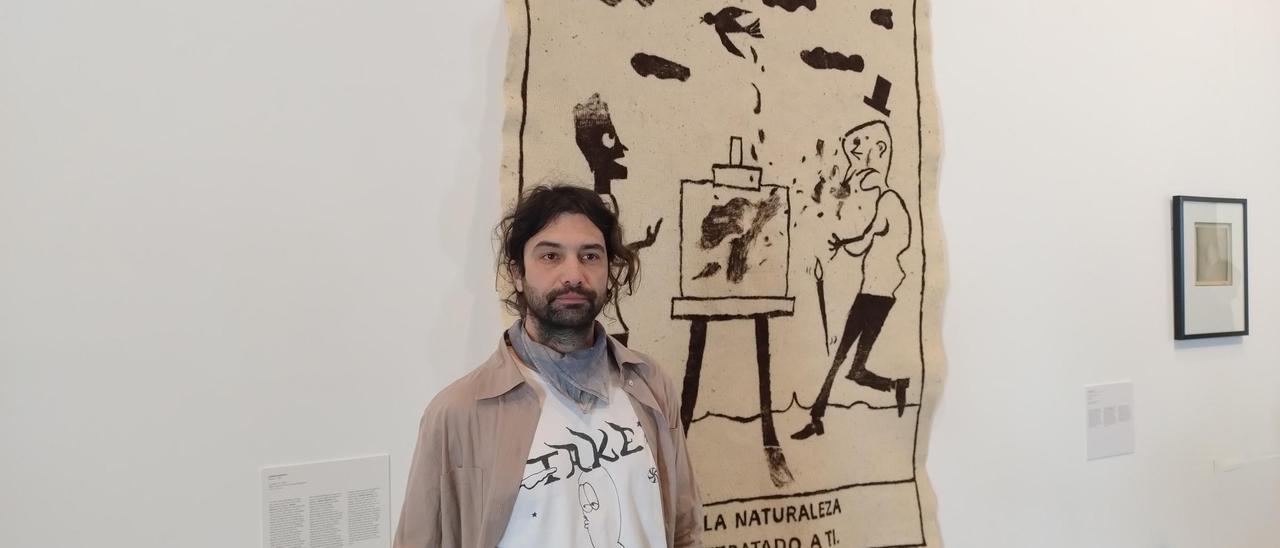 Adrián Martínez con la obra que tiene expuesta en 'MACE Focus 2024'.