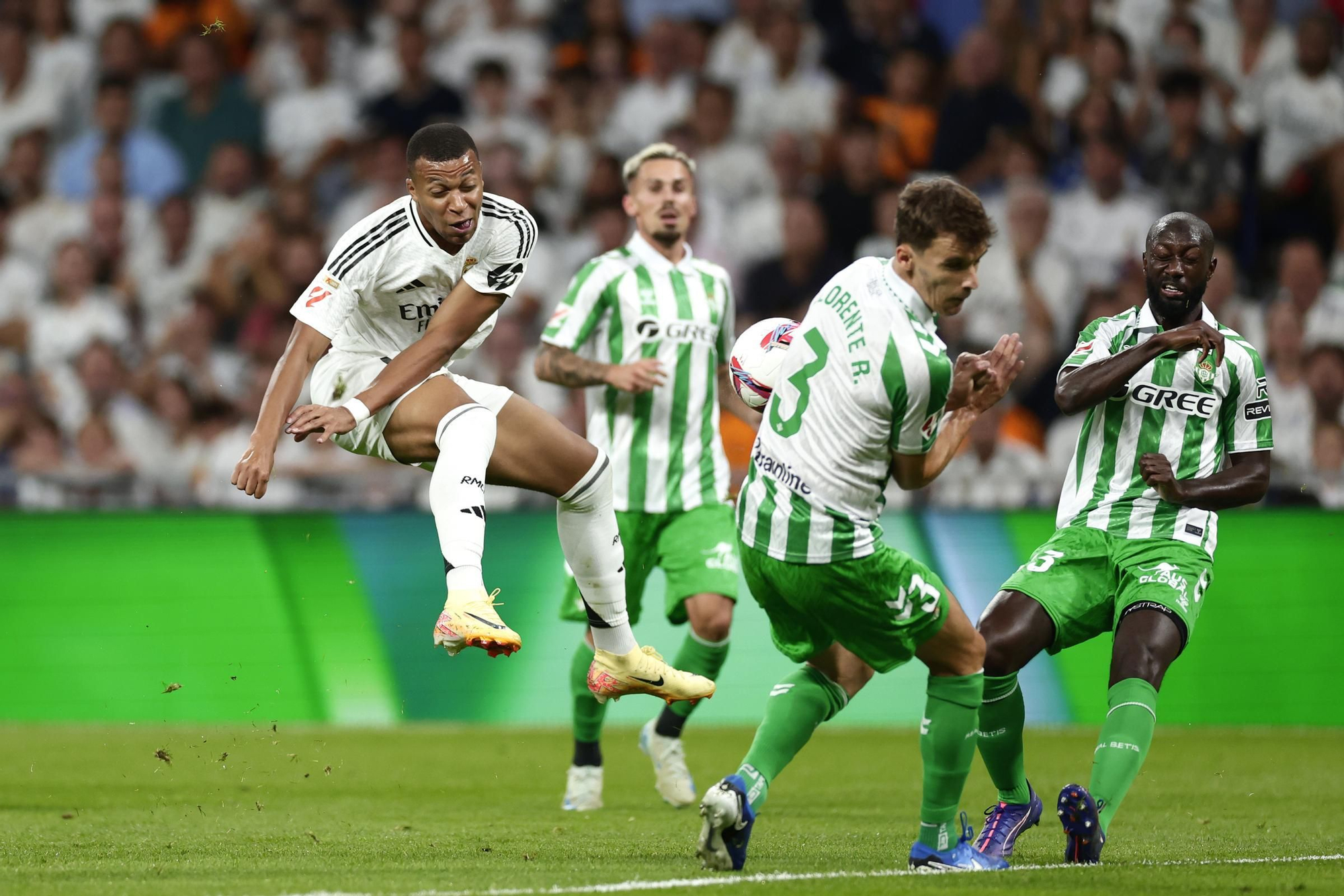 El jugador del Real Madrid Kylian Mbappe, a la izquierda, remata ante Diego Llorente, del Betis, durante el partido de la Liga española de fútbol entre el Real Madrid y el Betis en el estadio Santiago Bernabéu de Madrid, España, el domingo 1 de septiembre de 2024. 
