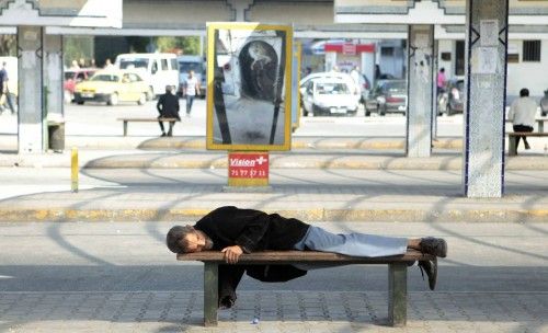 A man sleeps on a bench at a bus station in Tunis