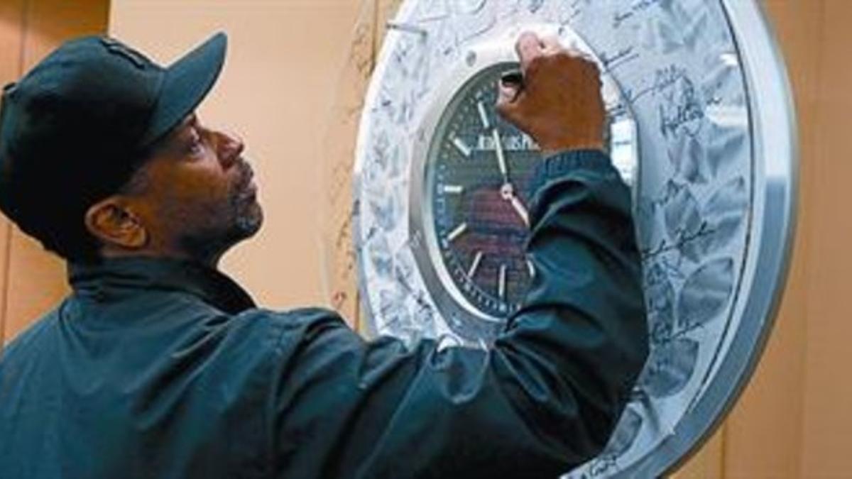 Denzel Washington firma un reloj tras su nominación, ayer.