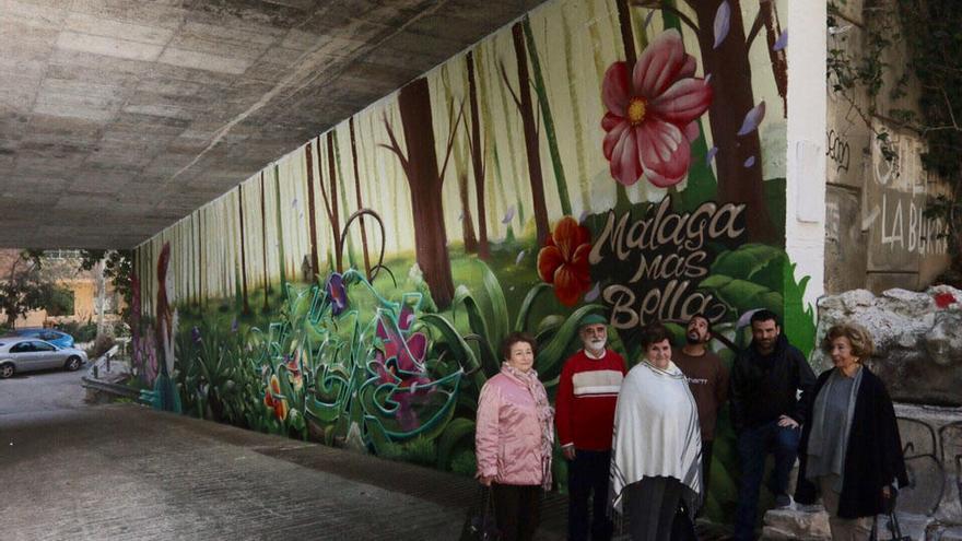 Miembros de las asociaciones y los autores del grafiti, frente a uno de los laterales del túnel.