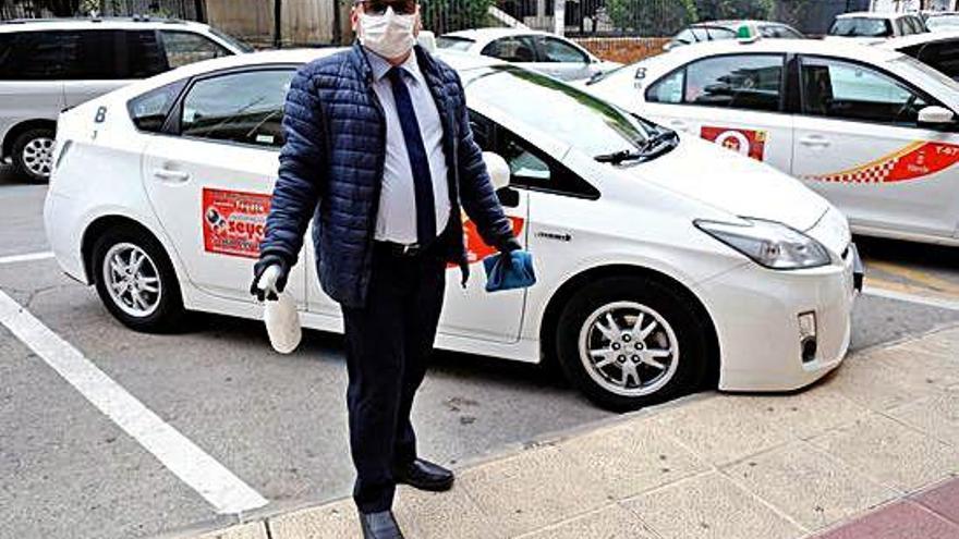 Sergio Navarro, presidente de Radio Taxi Murcia, con mascarilla frente a su vehículo.