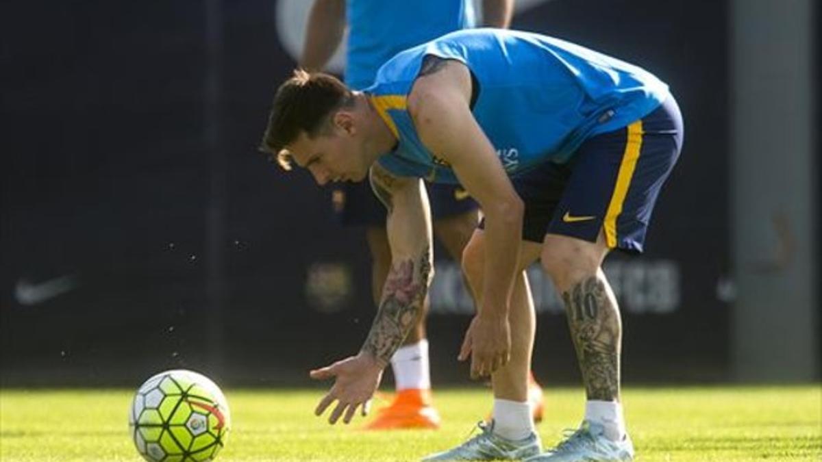 Messi se dispone a recoger el balón durante el entrenamiento de ayer en la ciudad deportiva de Sant Joan Despí.