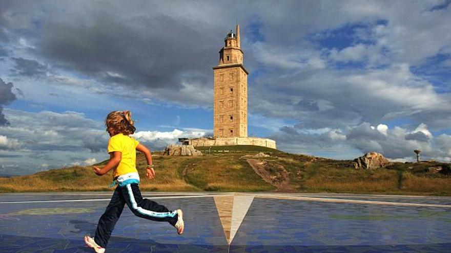 Una niña corre en la Rosa de los Vientos, con la Torre de Hércules al fondo. / carlos pardellas