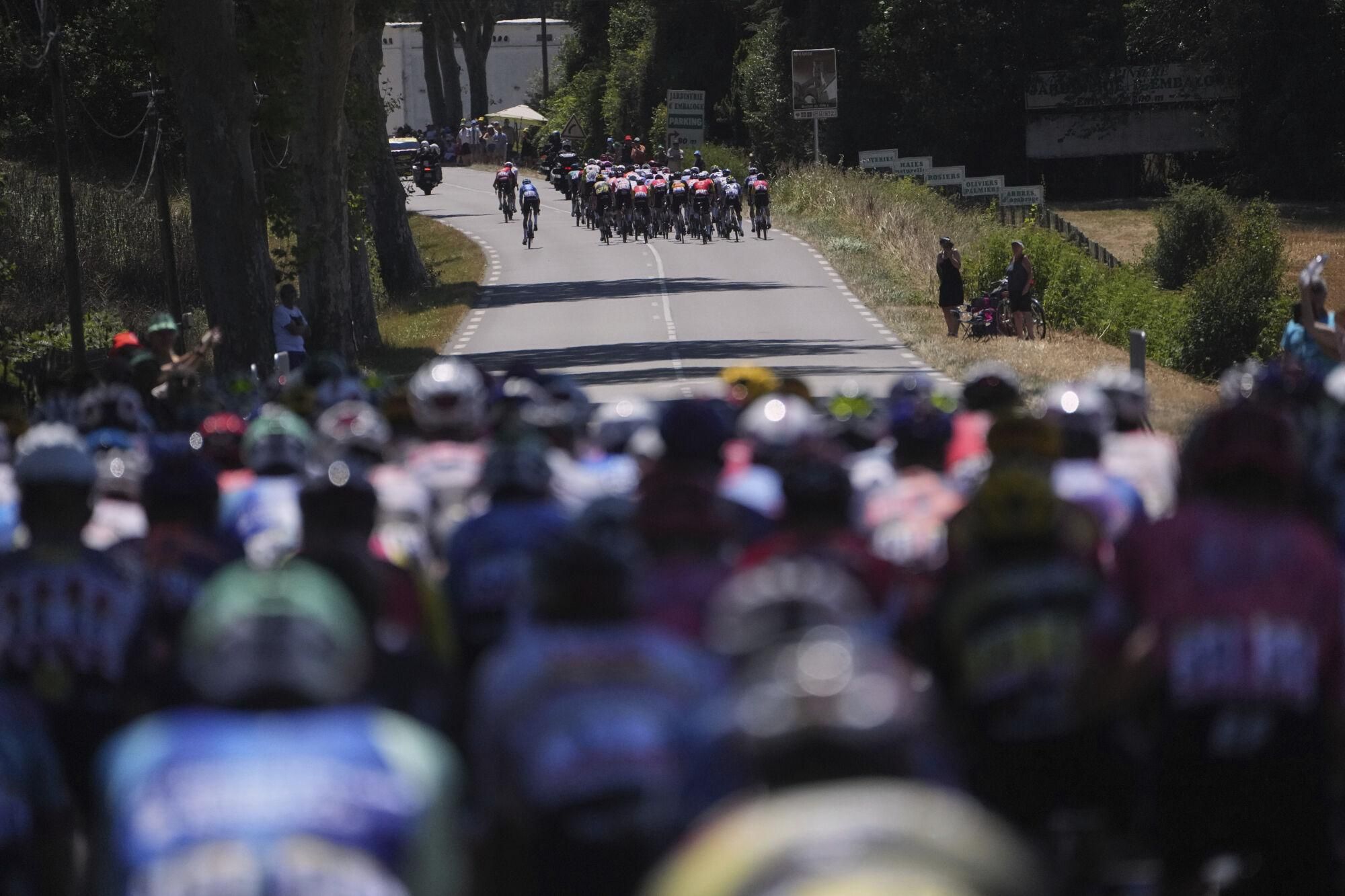 The pack watches a large group of about 50 riders break away during the twelfth stage of the Tour de France cycling race over 180.6 kilometers (112.2 miles) with start in Auch and finish in Hautacam, France, Thursday, July 17, 2025. (AP Photo/Thibault Camus)