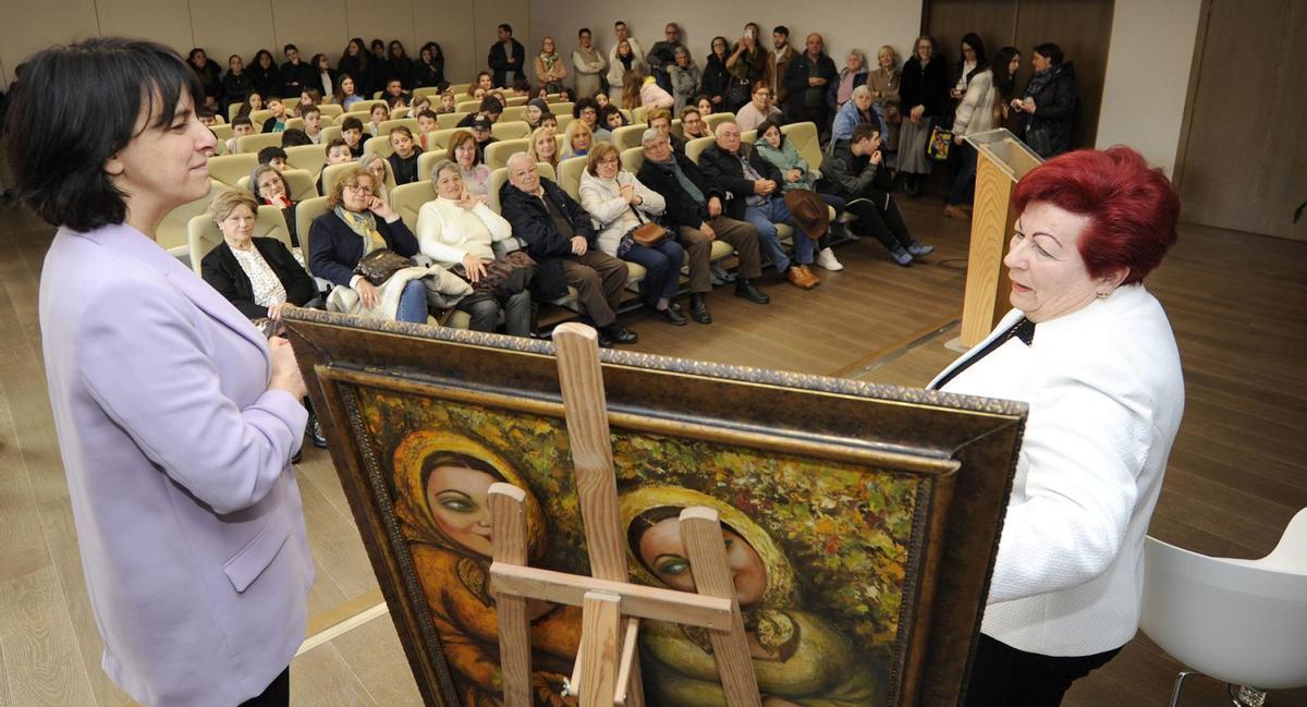 Marisa Miguélez le a súa dedicatoria no cadro ‘Amigas’, que doou ao Concello de Silleda, en presenza da alcaldesa. | // BERNABÉ/JAVIER LALÍN