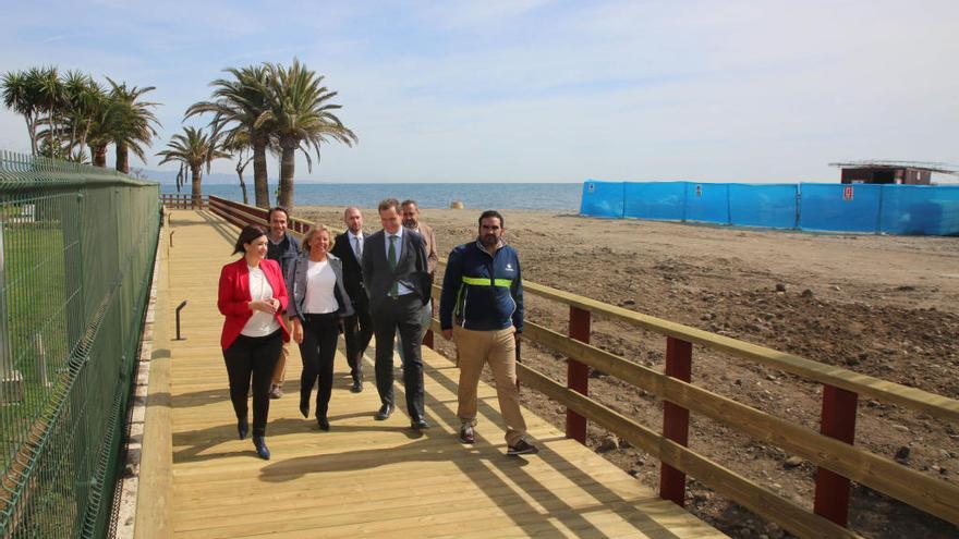 Representantes de autoridades locales pasean por el tramo de Senda Litoral abierta al público ayer.