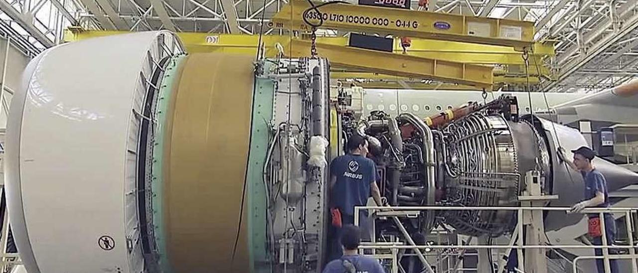 Tres empleados trabajan en un motor de un avión Airbus A380 durante su construcción. // Airbus