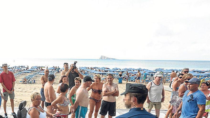 Un policía junto a un grupo de turistas.