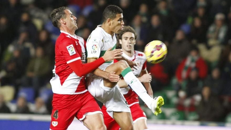 El delantero brasileño del Elche Jonathas de Jesus (d) intenta controlar el balón