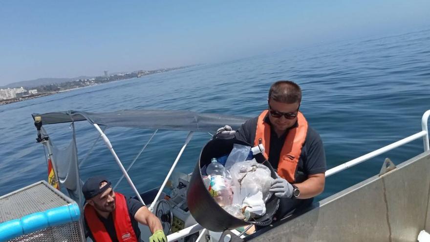 Un operario descarga un cubo con restos plásticos. | L.O.