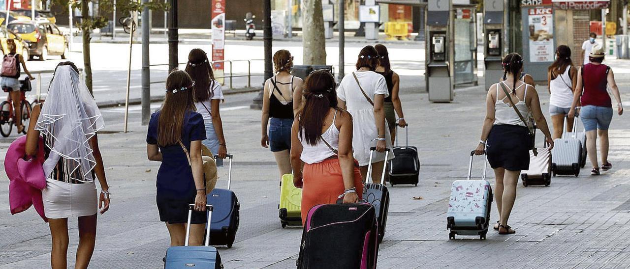 Varios turistas con sus maletas, ayer, en la plaza Cataluña, en Barcelona.