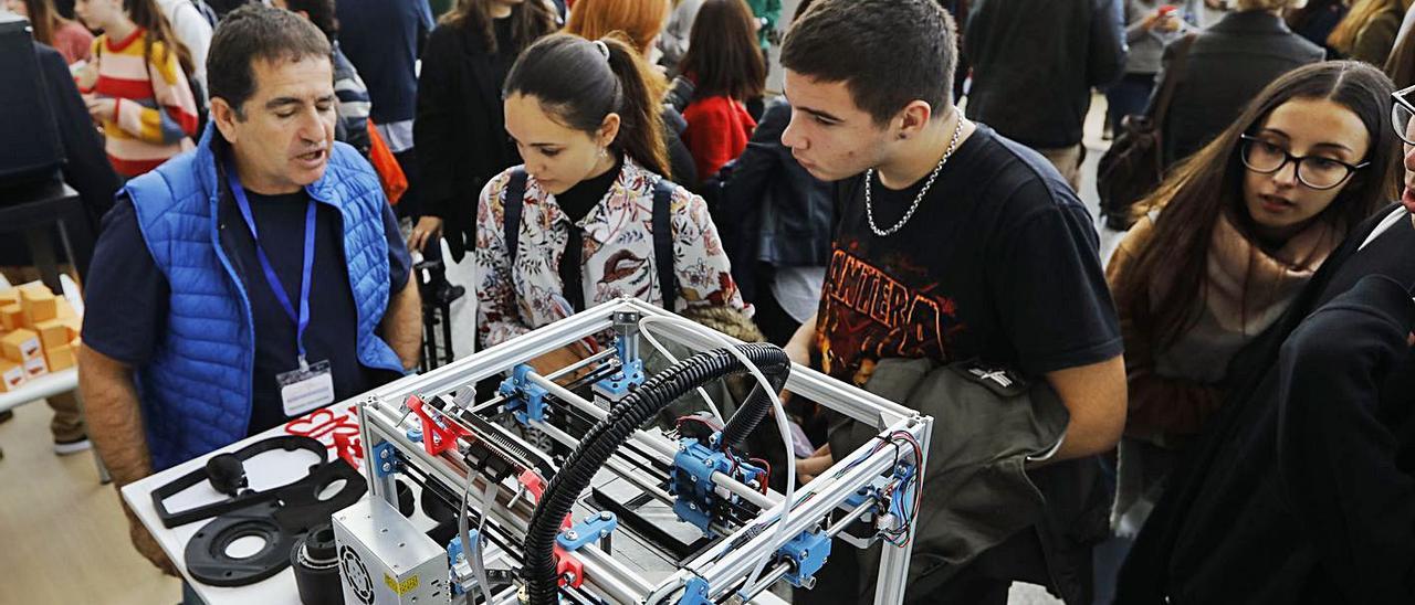 Un grupo de estudiantes, atienden explicaciones en la feria de FP de 2018 en València. | M.Á.MONTESINOS