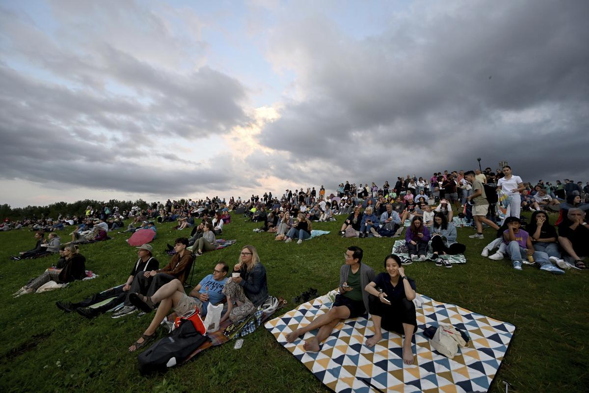 Los espectadores se sientan en la colina de observación del Parque Riemer en el primero de diez conciertos de la cantante británica Adele en Munich.