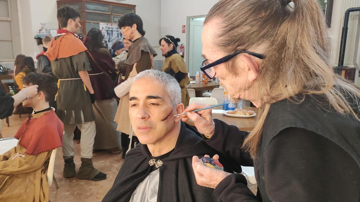 L'Esteve Porta dibuixant una cicatriu al rostre d'un dels actors de la Fira de l'Aixada