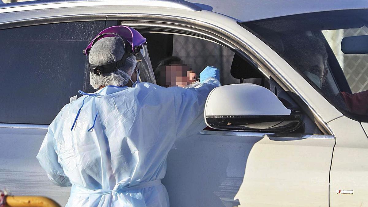 Una sanitaria toma una muestra a una mujer para hacer una PCR, en una foto de archivo. | F. CALABUIG