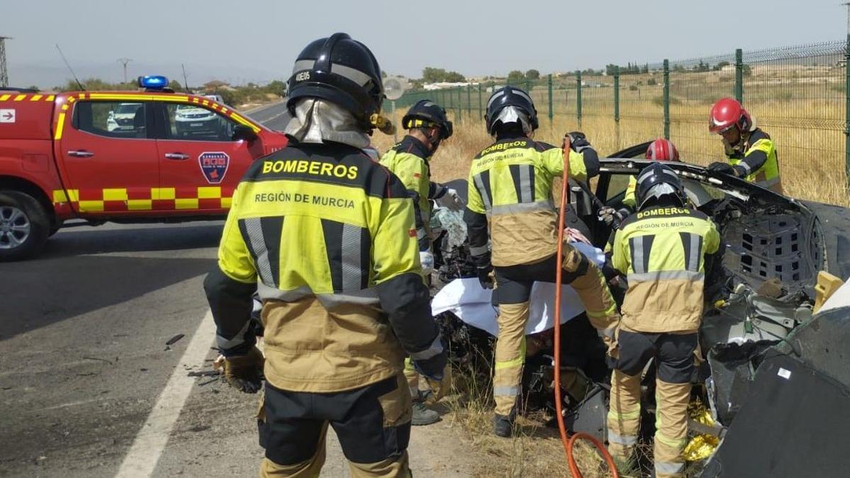 Bomberos trabajan en el lugar del siniestro mortal.